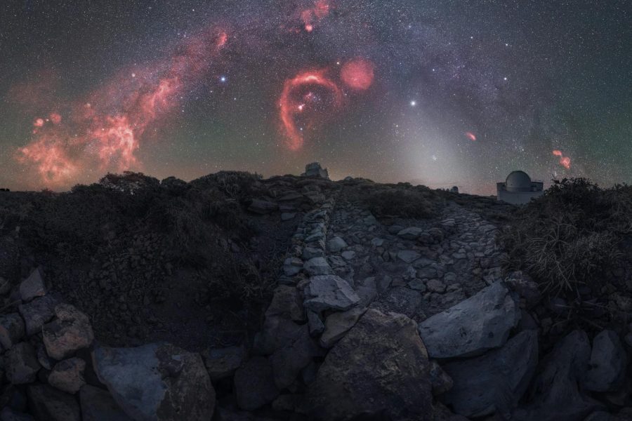 Breathtaking view of the Milky Way and celestial formations over rugged terrain.